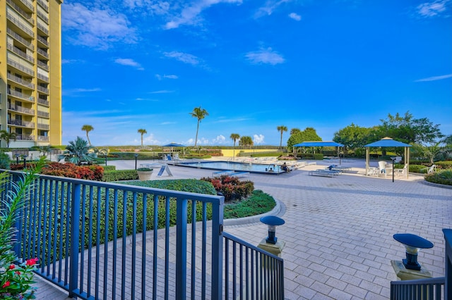 view of property's community with a swimming pool and a patio