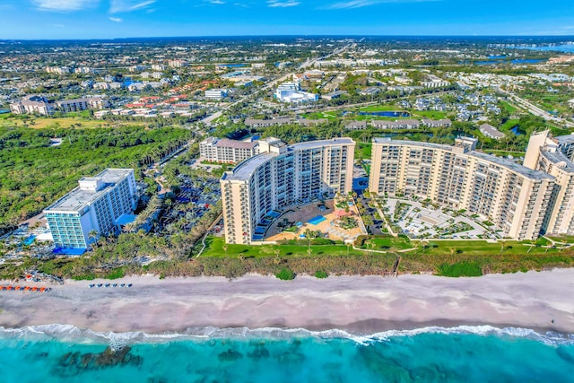 birds eye view of property featuring a water view and a beach view