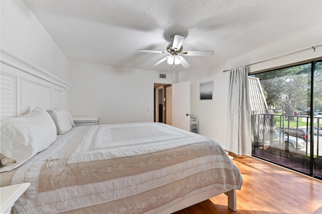 bedroom featuring wood-type flooring, access to outside, ceiling fan, and a textured ceiling