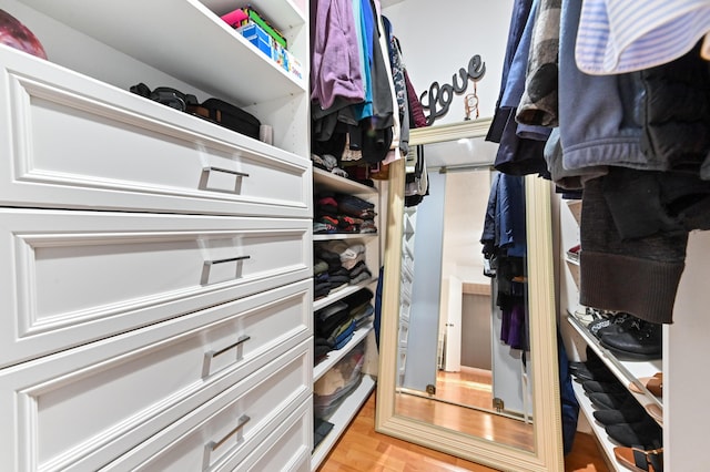 walk in closet with light hardwood / wood-style flooring