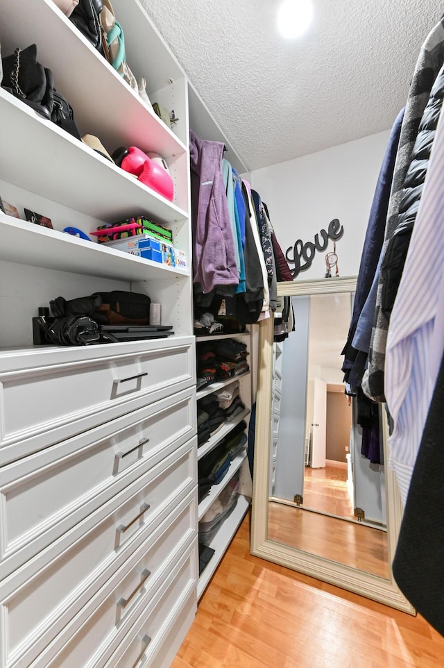 walk in closet with light wood-type flooring