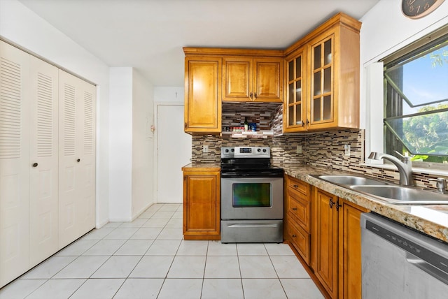 kitchen featuring sink, decorative backsplash, stainless steel appliances, and light tile patterned flooring