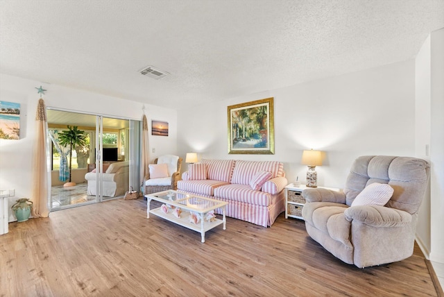 living room with hardwood / wood-style flooring and a textured ceiling