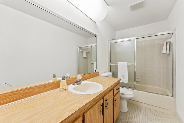 full bathroom featuring tile patterned flooring, vanity, combined bath / shower with glass door, and toilet