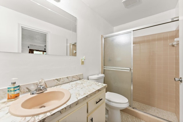 bathroom featuring vanity, an enclosed shower, and toilet