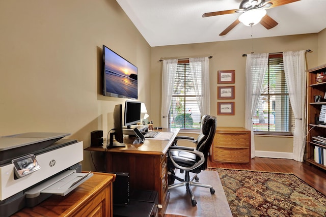 office featuring dark wood-type flooring, vaulted ceiling, baseboards, and a ceiling fan