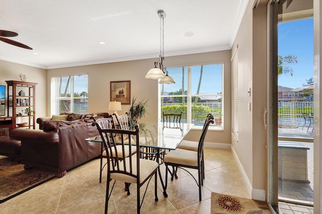 dining space featuring a ceiling fan, crown molding, baseboards, and light tile patterned floors