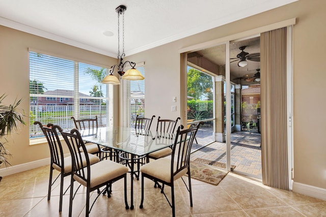 dining area with a ceiling fan, crown molding, baseboards, and light tile patterned floors