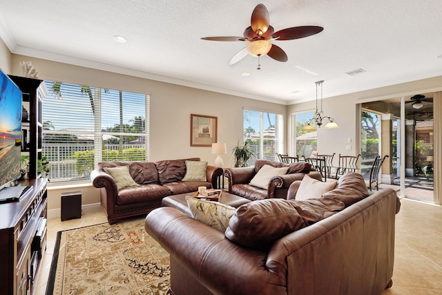 living room with ornamental molding, ceiling fan with notable chandelier, light tile patterned floors, and a textured ceiling