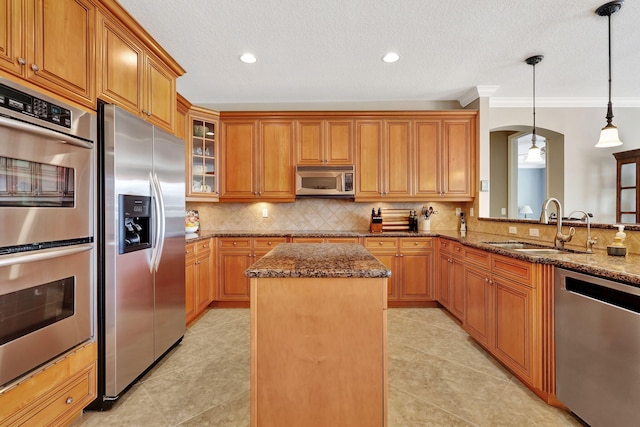 kitchen with dark stone countertops, stainless steel appliances, tasteful backsplash, a kitchen island, and decorative light fixtures