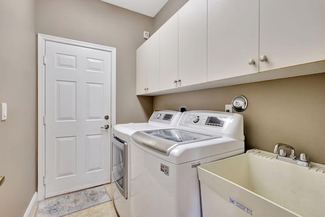 laundry area with cabinets, washing machine and dryer, sink, and light tile patterned flooring