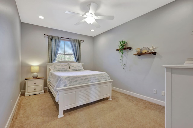 bedroom with a ceiling fan, light colored carpet, and baseboards