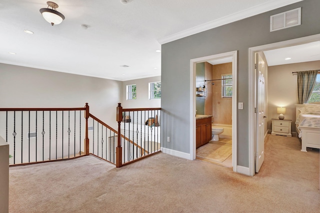 hallway featuring light colored carpet and ornamental molding