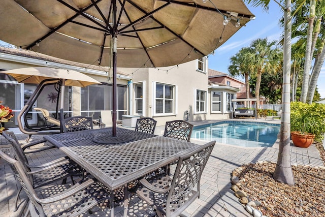 view of pool with a fenced in pool, outdoor dining space, a patio, and fence