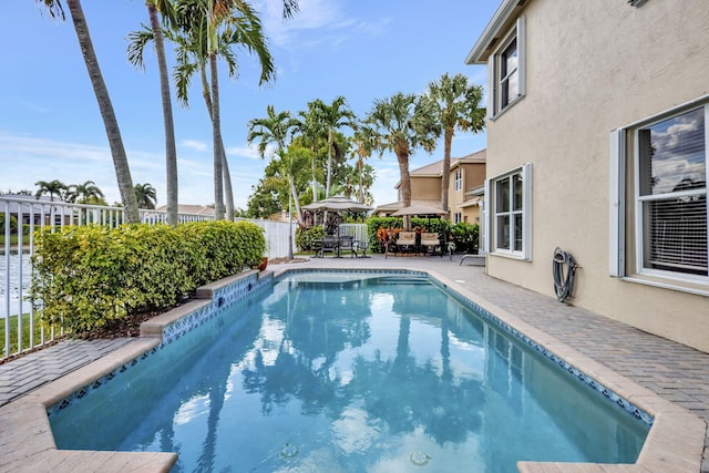 view of pool with a patio area, fence, outdoor dining area, and a fenced in pool