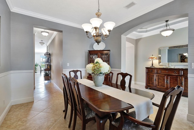 dining space featuring arched walkways, light tile patterned floors, visible vents, ornamental molding, and a chandelier