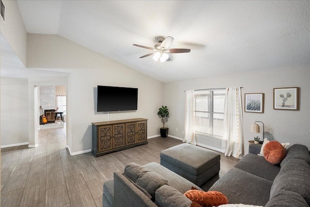 living room featuring vaulted ceiling, light hardwood / wood-style floors, and ceiling fan