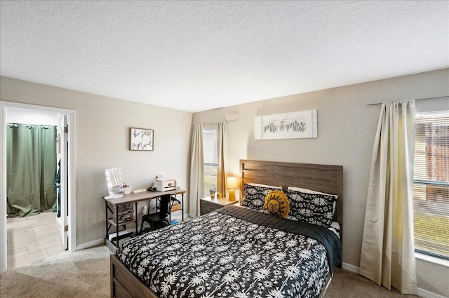 bedroom with light colored carpet and a textured ceiling