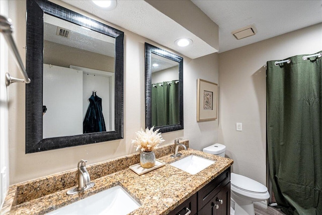 bathroom featuring walk in shower, vanity, and toilet