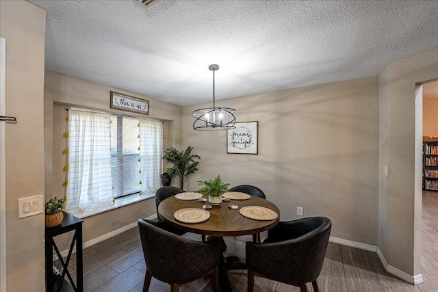 dining area with hardwood / wood-style floors and a textured ceiling