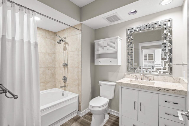 full bathroom featuring visible vents, toilet, wood finished floors, shower / bath combination with curtain, and vanity