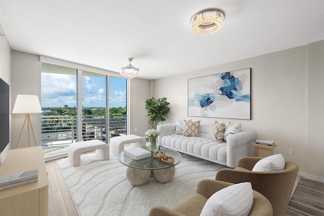 living area with expansive windows, a textured ceiling, baseboards, and wood finished floors