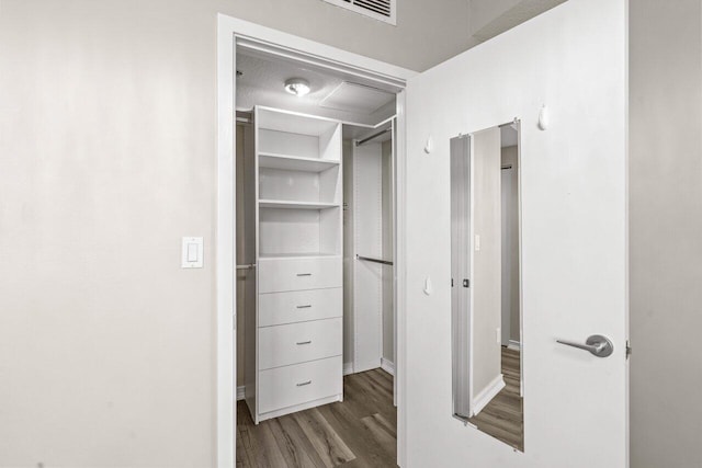 walk in closet with dark wood-type flooring