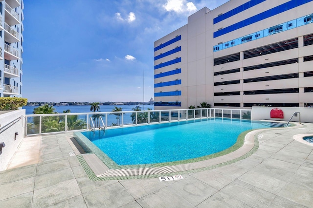 view of pool featuring a patio area and a water view