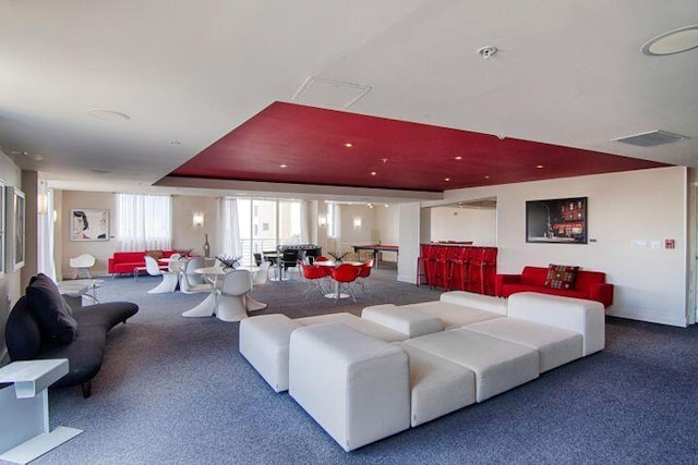 carpeted living room with a raised ceiling