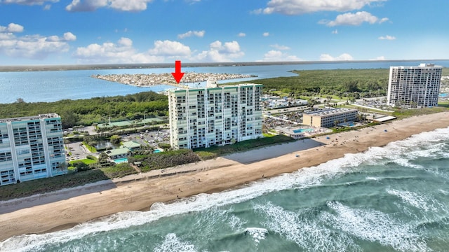 drone / aerial view featuring a water view and a view of the beach