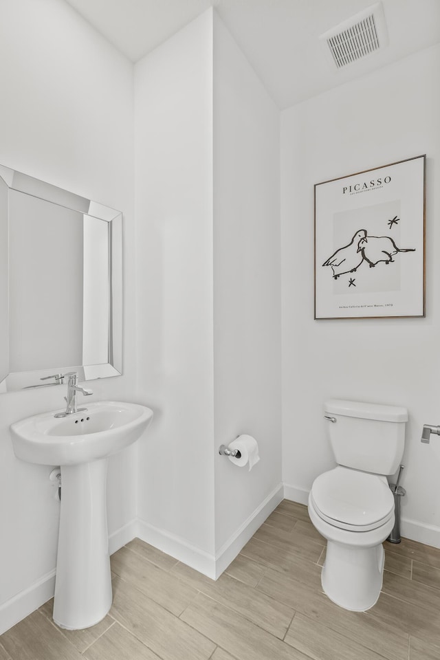 bathroom featuring hardwood / wood-style floors and toilet