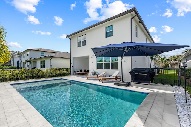 rear view of property with a fenced in pool and a patio