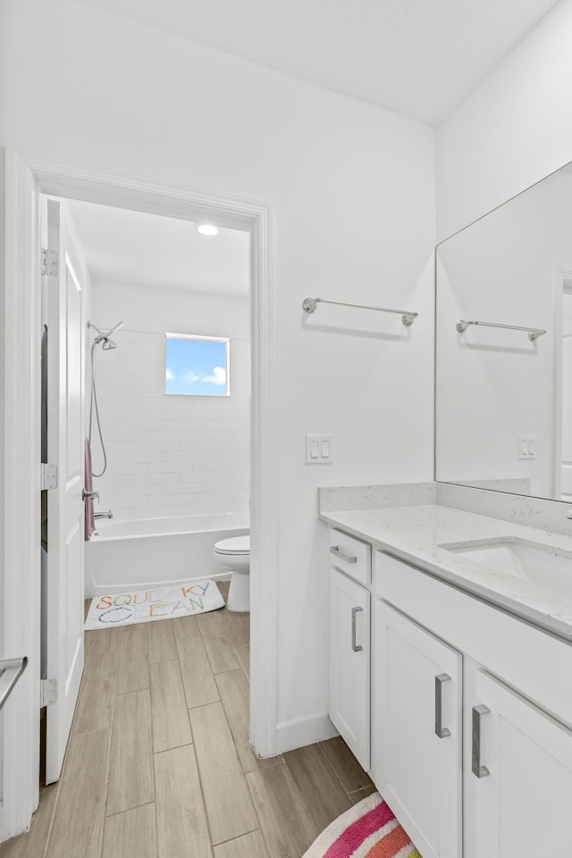 full bathroom with tiled shower / bath, vanity, and toilet