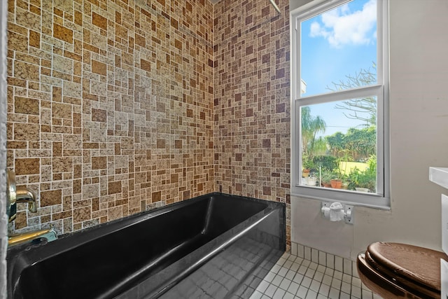 bathroom featuring tile patterned floors, a bathtub, and toilet