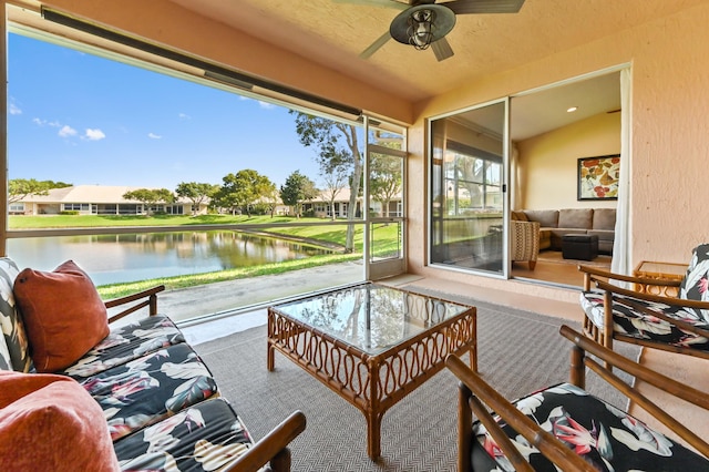 sunroom with lofted ceiling, ceiling fan, and a water view