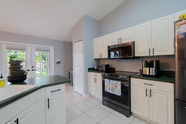 kitchen featuring vaulted ceiling, light tile patterned flooring, white cabinets, stainless steel appliances, and french doors