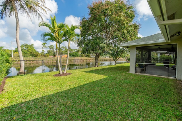 view of yard featuring a water view and a sunroom