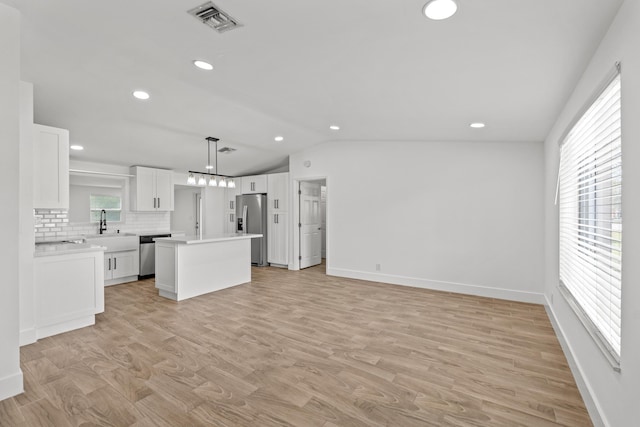 kitchen featuring hanging light fixtures, white cabinetry, appliances with stainless steel finishes, and a kitchen island