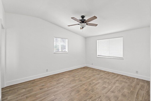 empty room with ceiling fan, lofted ceiling, and light hardwood / wood-style floors