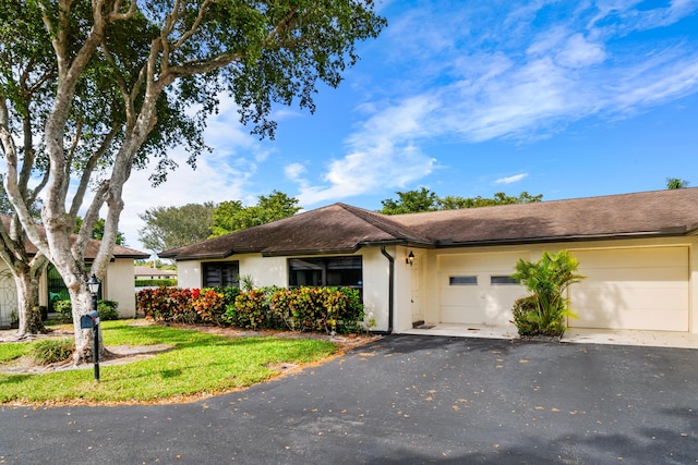 single story home featuring a garage and a front yard