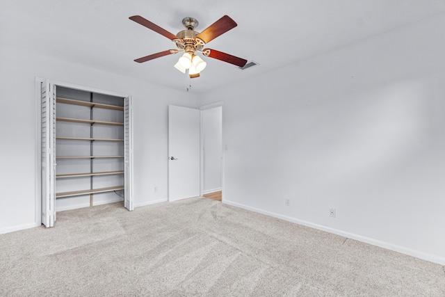 unfurnished bedroom with ceiling fan, a closet, and light carpet