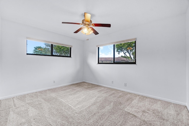 spare room featuring plenty of natural light, ceiling fan, and carpet flooring