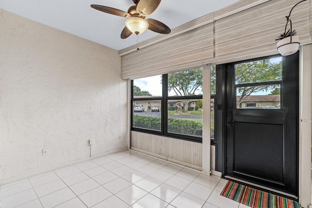 unfurnished sunroom featuring ceiling fan