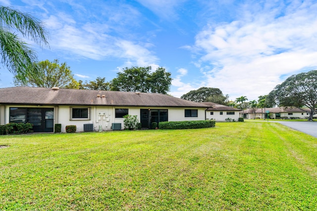 ranch-style home featuring cooling unit and a front yard