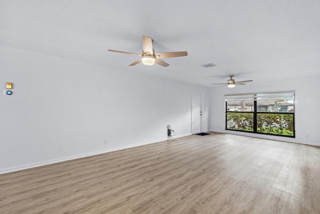 unfurnished living room with a textured ceiling, light hardwood / wood-style floors, and ceiling fan