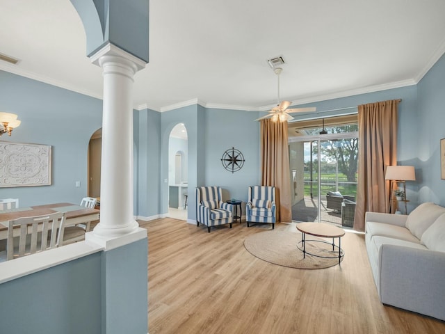 living room with crown molding, hardwood / wood-style floors, and ornate columns