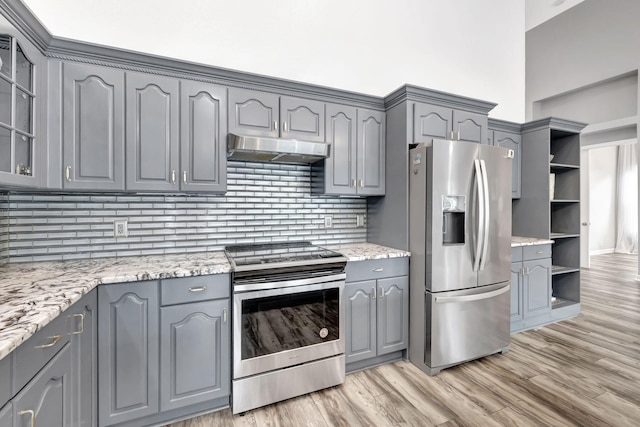 kitchen featuring stainless steel appliances, light stone countertops, light hardwood / wood-style floors, and gray cabinetry