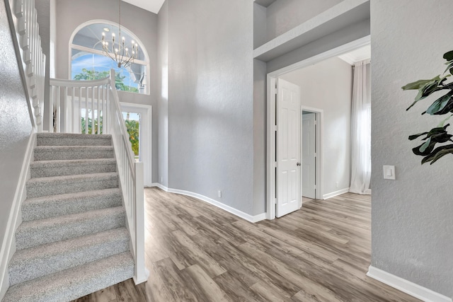 entrance foyer with a high ceiling, an inviting chandelier, and light hardwood / wood-style flooring