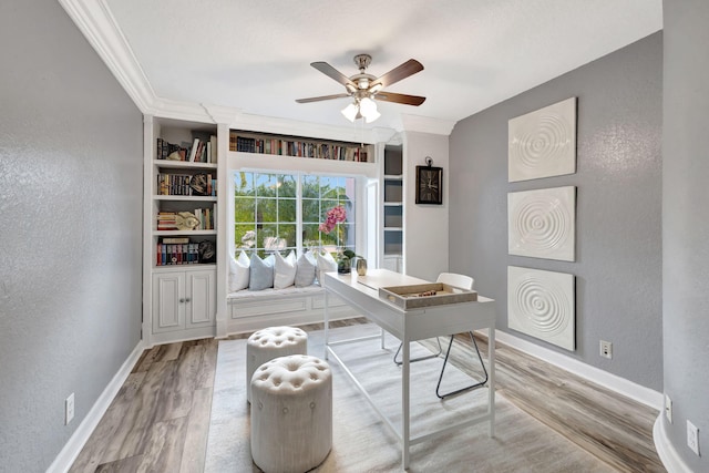 office with ornamental molding, hardwood / wood-style floors, ceiling fan, and built in shelves