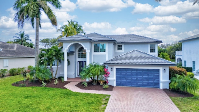 mediterranean / spanish-style home with a garage and a front yard